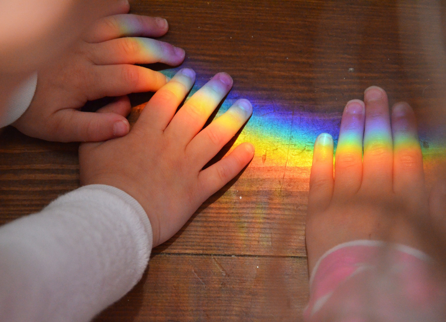 mani di bimbi e arcobaleno